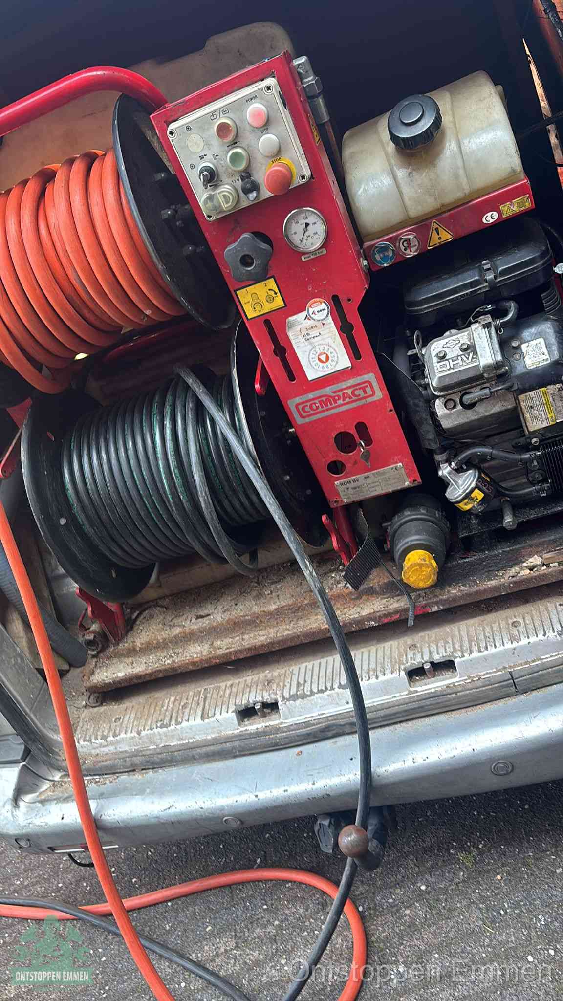 Een rood hogedruk-rioolreinigingstoestel in de laadbak van de bedrijfsbus, apparatuur voor een hardnekkige afvoerverstopping in Emmen