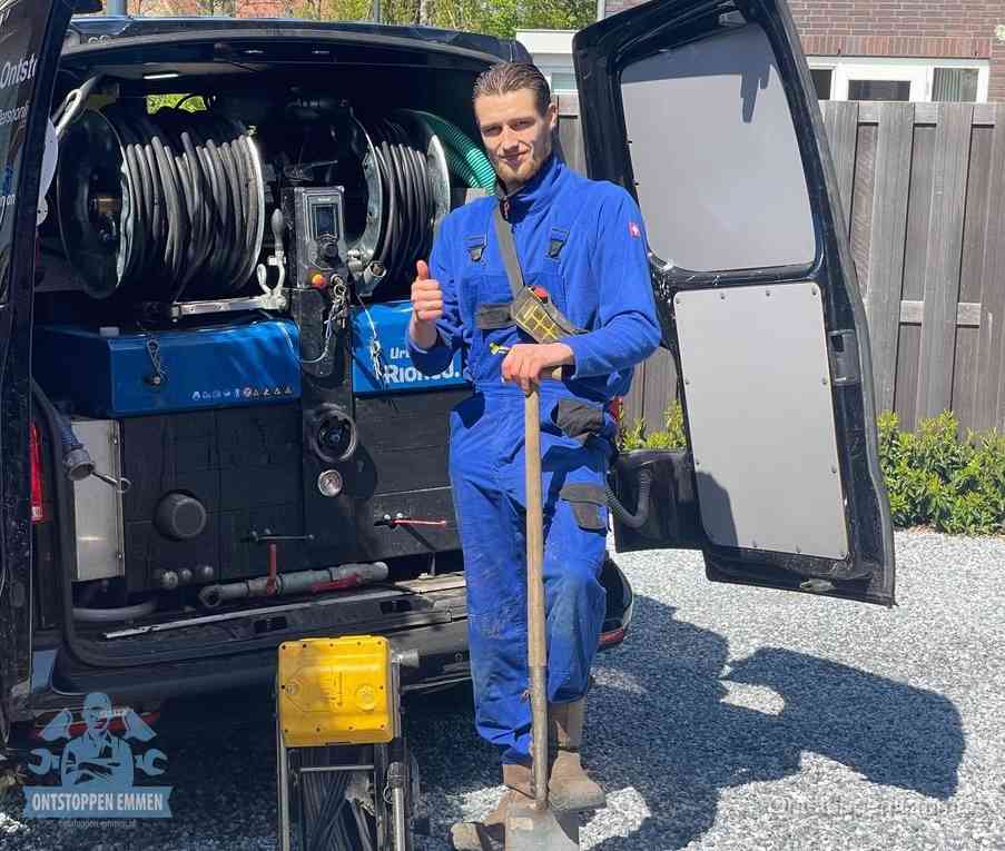 Een monteur bij de werkbus met grote hogedruk-slanghaspels, apparatuur voor hardnekkige afvoerverstoppingen in Emmen