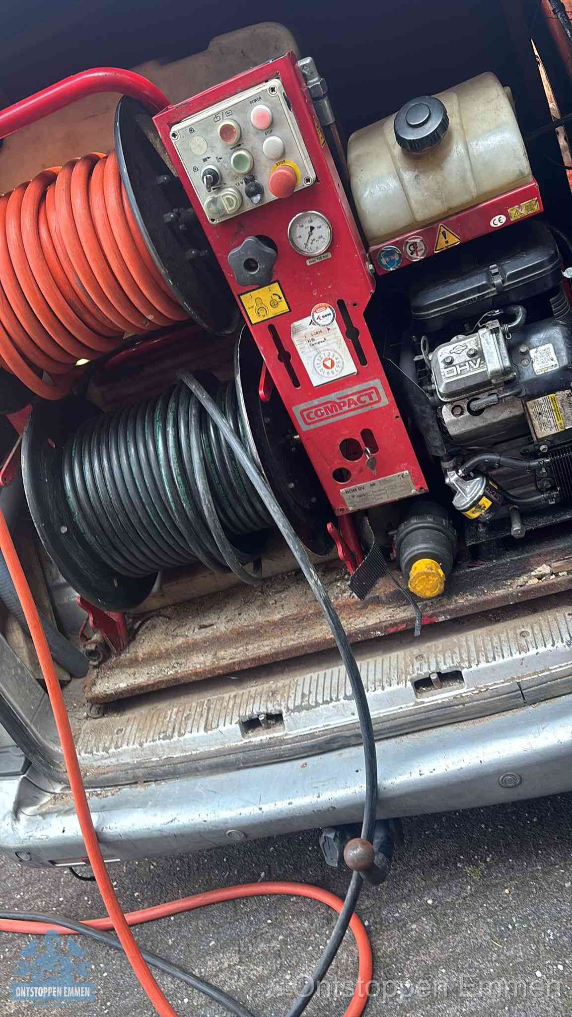 Een rood hogedruk-rioolreinigingstoestel met slangen in de laadbak van de bedrijfsbus, apparatuur voor een hardnekkige wc-verstopping in Emmen