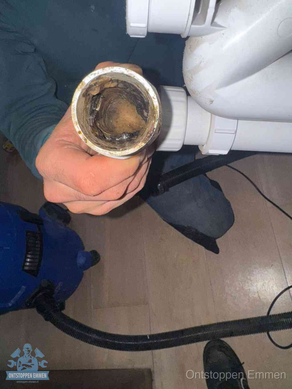 Een losgekoppelde afvoerbuis die van binnen volledig is dichtgeslibd met vet en aanslag, de meest voorkomende oorzaak van een verstopte gootsteen in Emmen