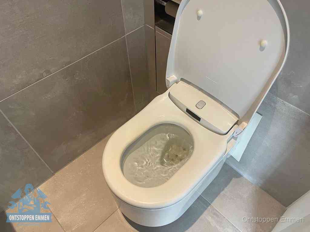 Een toiletpot vol troebel water met drijvend papier en restanten, de meest voorkomende oorzaak van een verstopte wc in Emmen