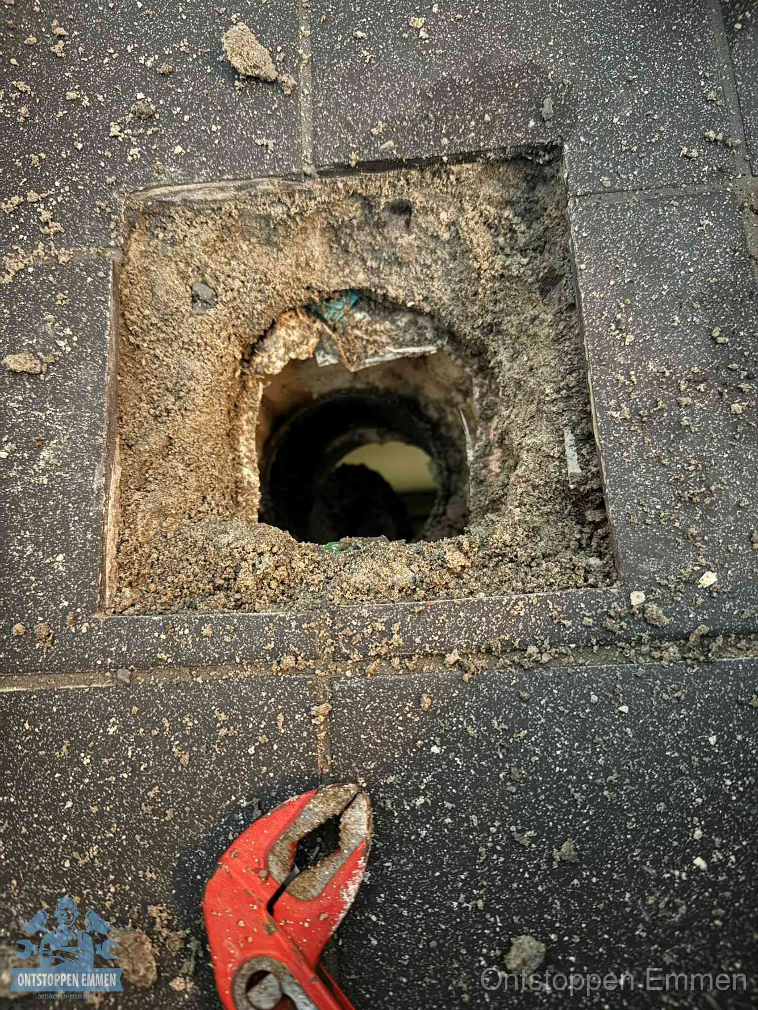Geopend rioolputje op de erfgrens dat laat zien wie eigenaar is van de riolering in Emmen