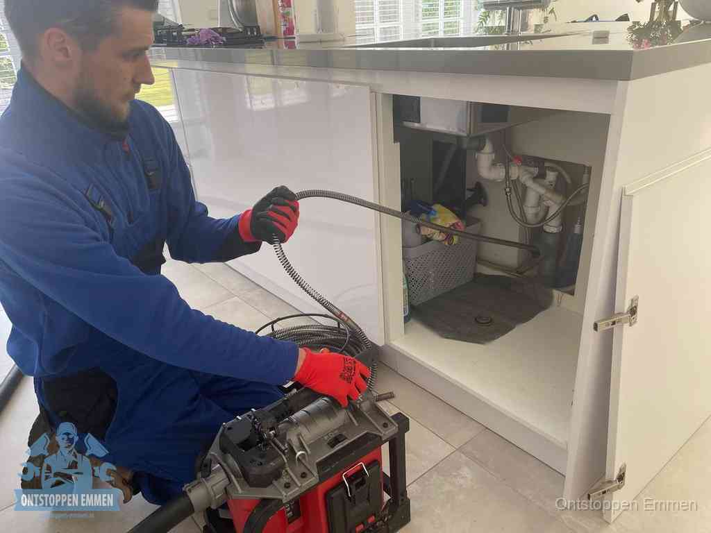 Een monteur reinigt de keukenafvoer grondig met een veermachine om terugkerende gootsteenverstoppingen te voorkomen in Emmen